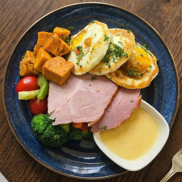 Fittery signature baked eggs and ham breakfast with sweet potato and cream cheese on a plate.