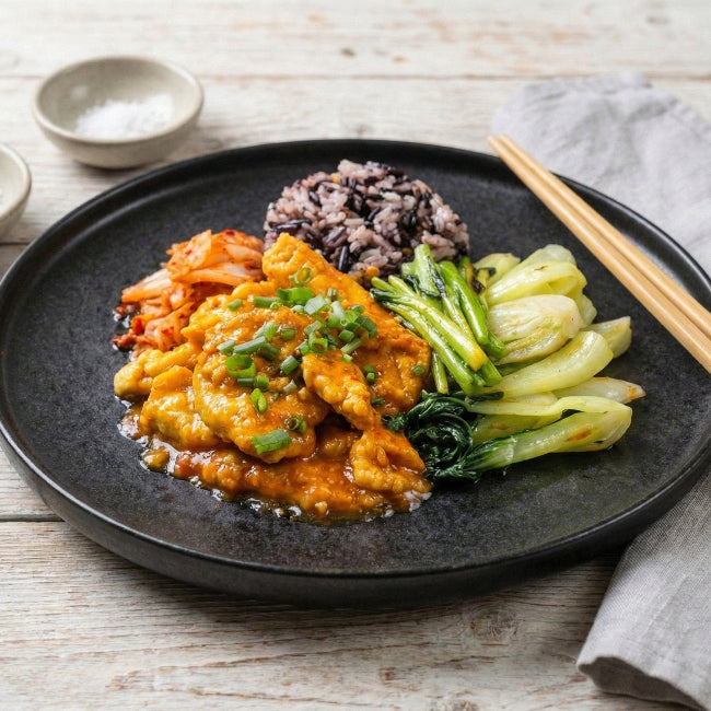 Stir-fried kimchi with lean pork loin, sautéed vegetables, and purple mix grain rice in a signature Fittery meal bowl.